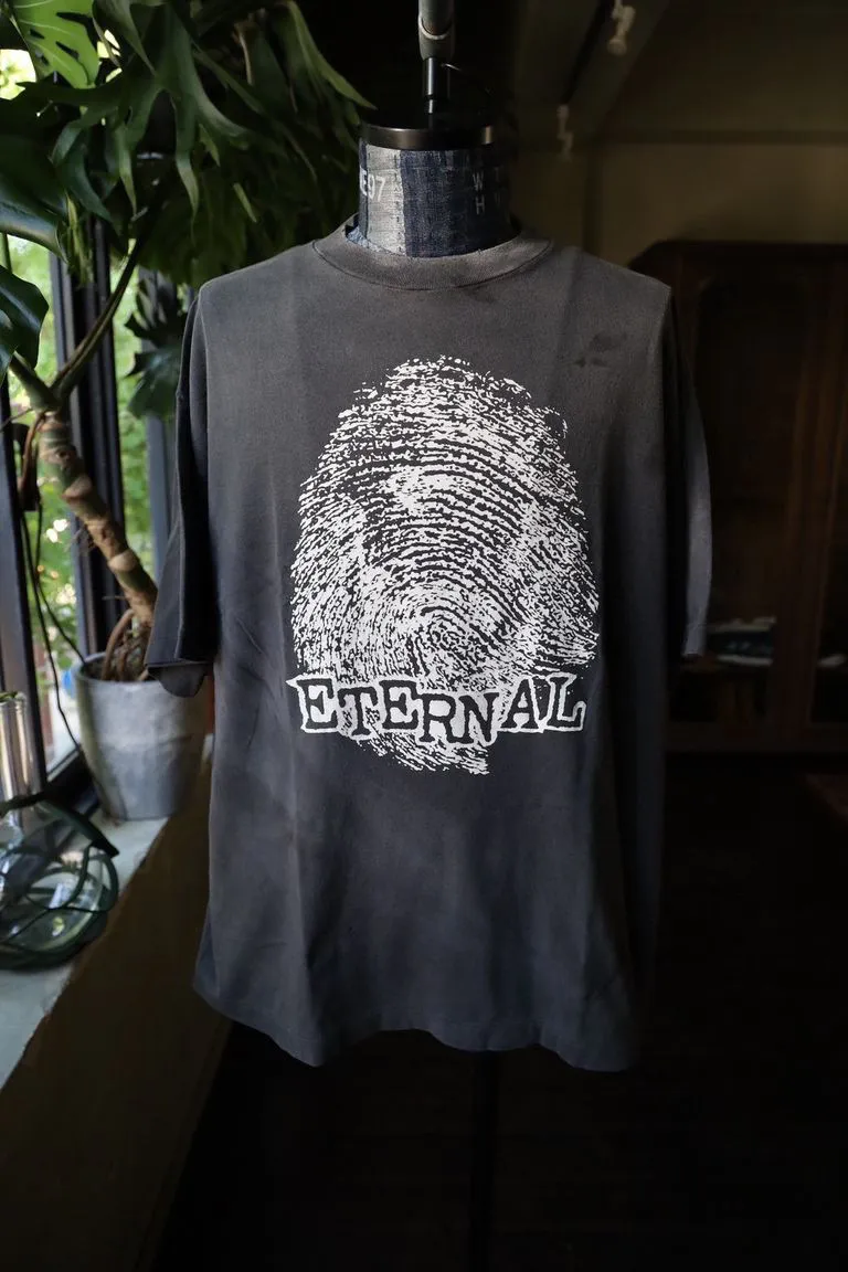 SAINT Mxxxxxx CHOSEN SS TEE/BLK Burst pattern/fingerprint print Chosen Tee Washed black S-XL Look for cylindrical fabrics without side seams. Don’t buy open-width fabrics anymore. It’s boring. Assute garment dyeing. Spray the whole piece with Ma Liu. Re-spray heavy fade. Collar and cuffs are frayed. Many places are broken. Authentic grade printing restored. Original consistent main mark/wash mark/with little angel anti-counterfeiting label.